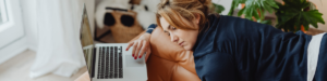 Mulher deitada com notebook e exausta